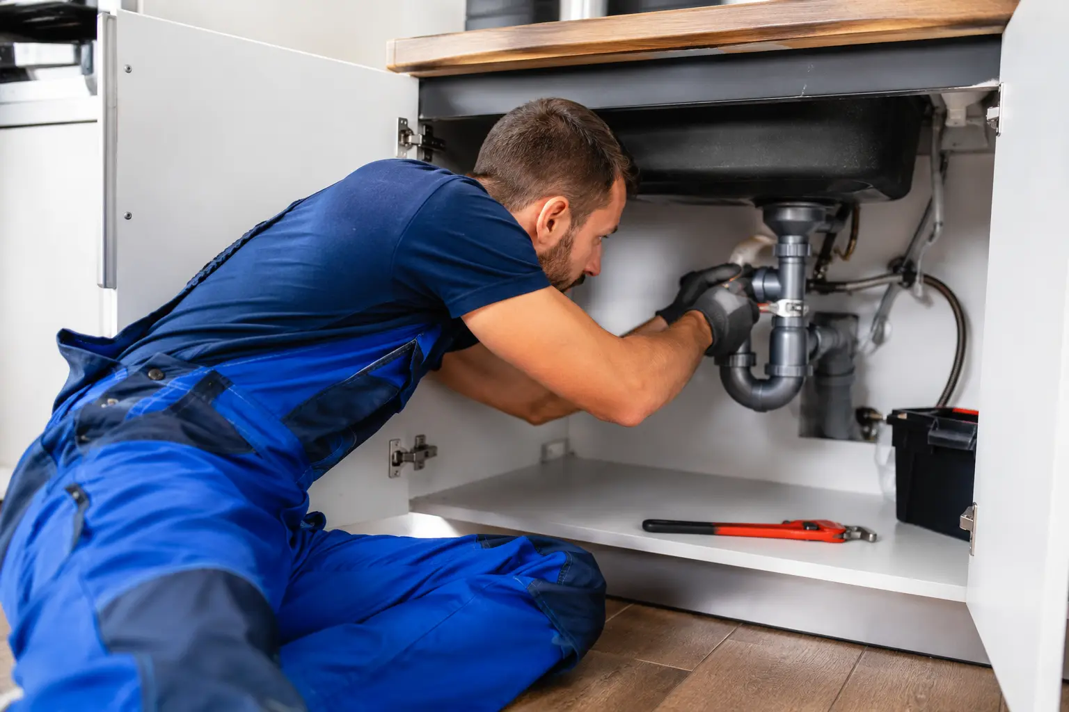Plumber fitting pipework in a home in Manchester