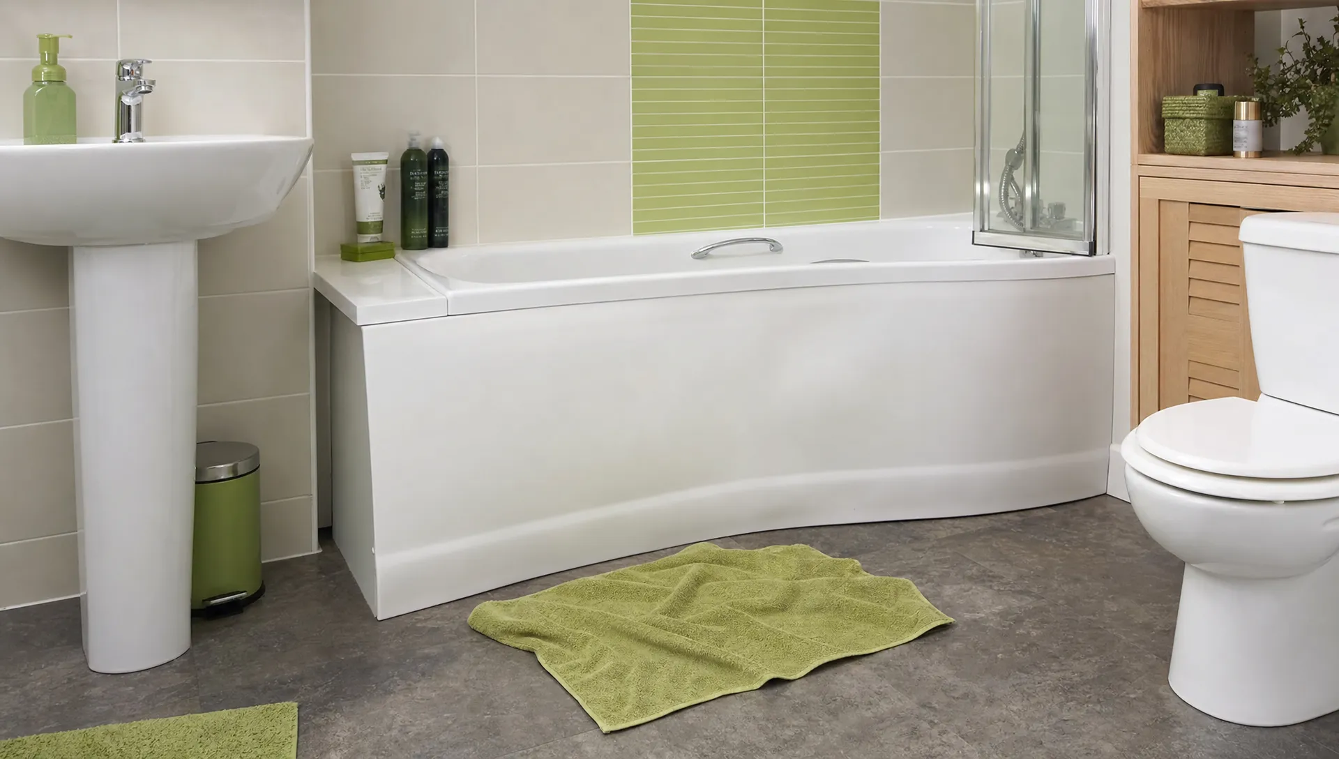 A slightly bowed white bath panel below a bathtub in an ordinary UK bathroom, with a small towel on the floor and everyday bathroom items visible from a normal standing distance.