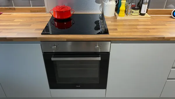 induction hob with red lidded pan on top